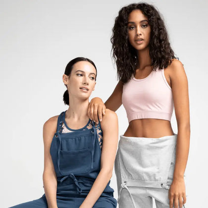 Deux femmes portant des bas féminins : une salopette bleue et un short gris, représentant la diversité et le style décontracté et élégant de la collection de bas pour femme.